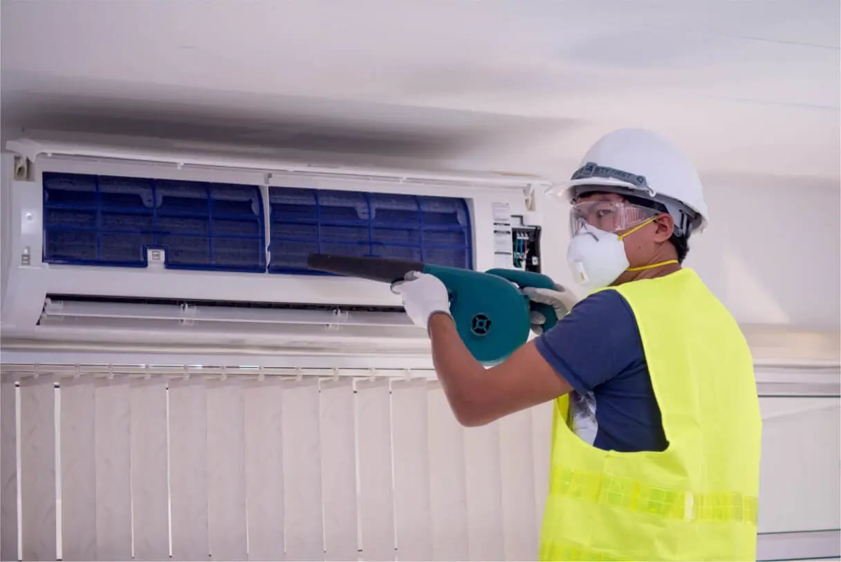 happy-male-technician-repairing-air-conditioner-with-safety-hat-air